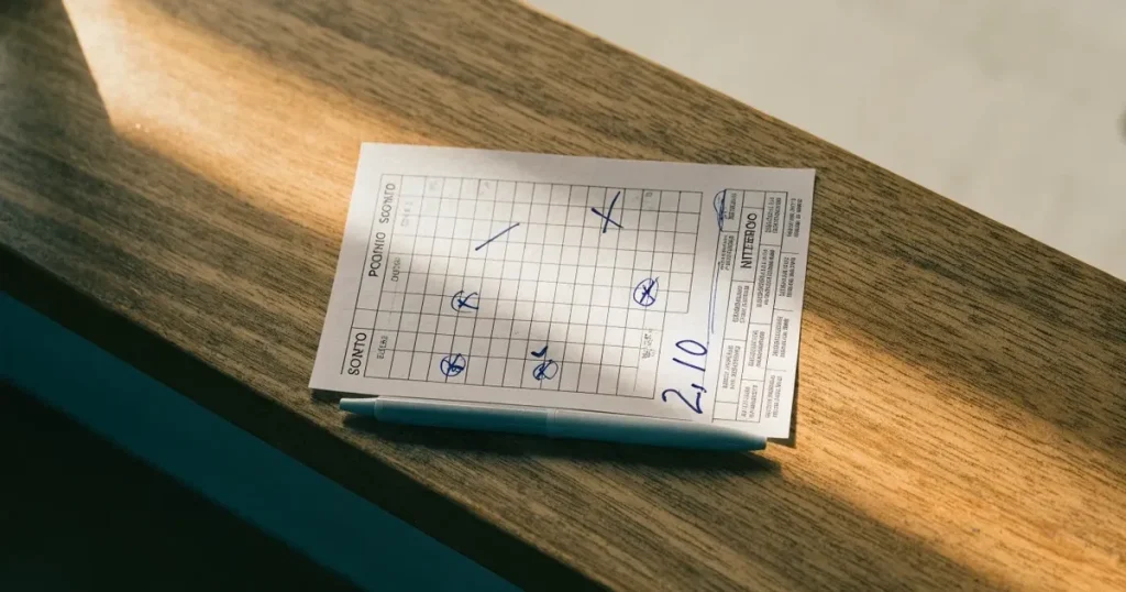 Una schedina con diverse selezioni segnate a penna su un bancone di legno